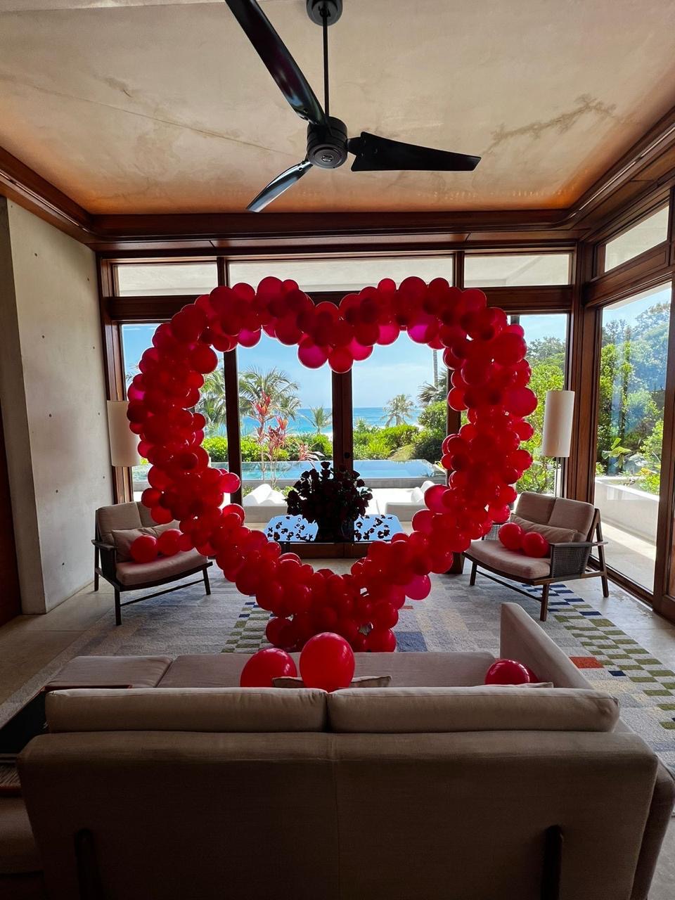 Arco de globos en forma de corazón rojo frente al mar