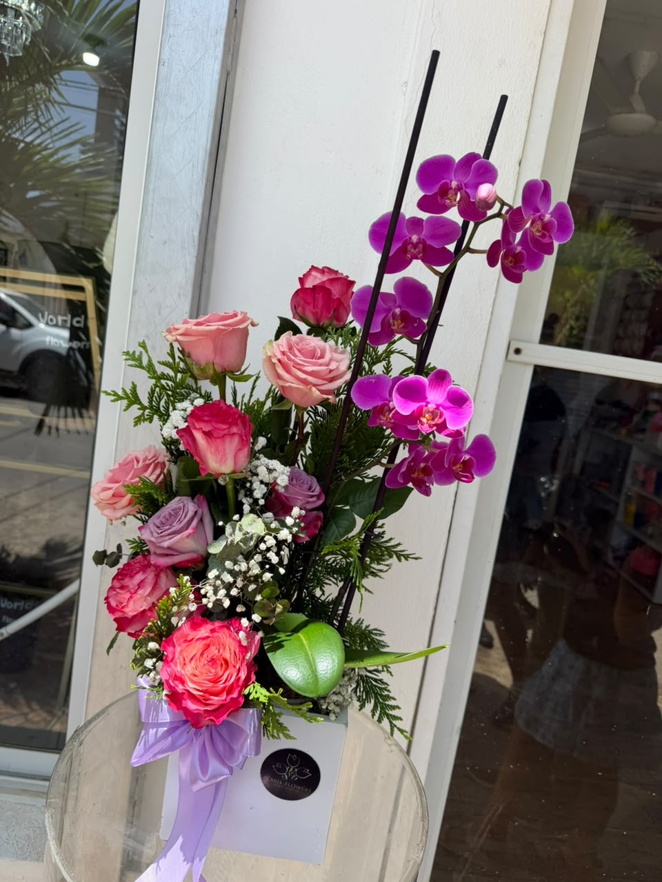 Arreglo con rosas multicolor y orquídeas moradas