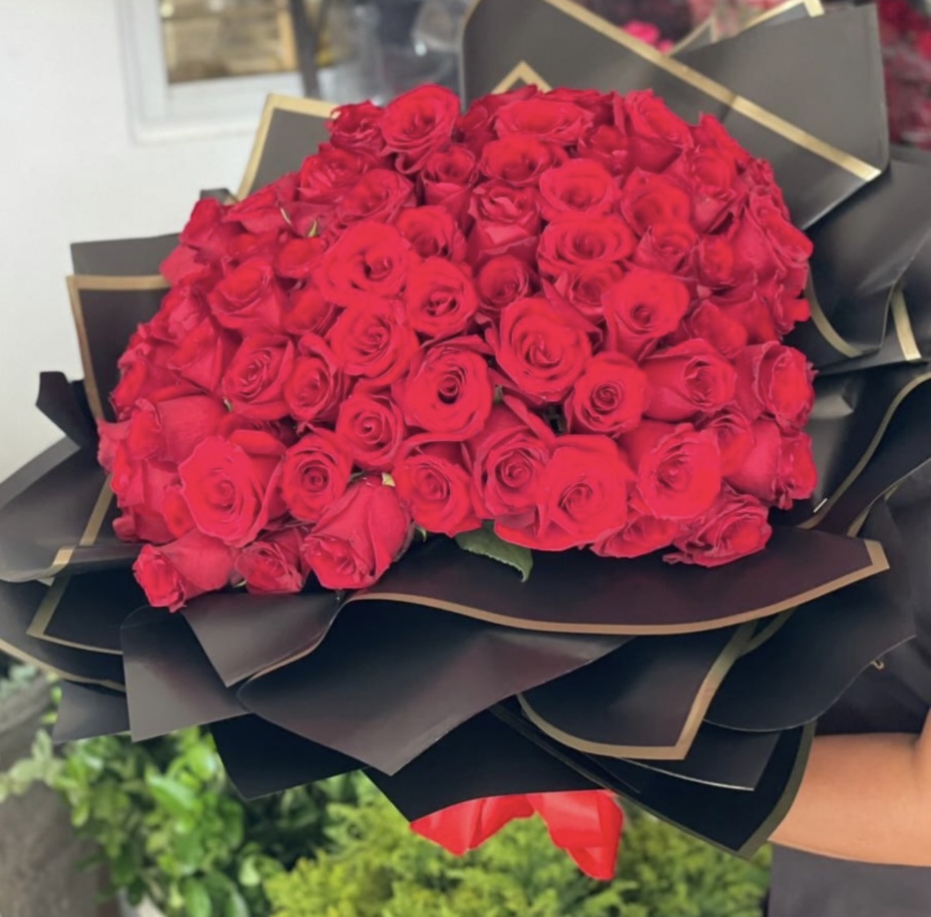 Ramo grande de rosas rojas con envoltura negra y dorada