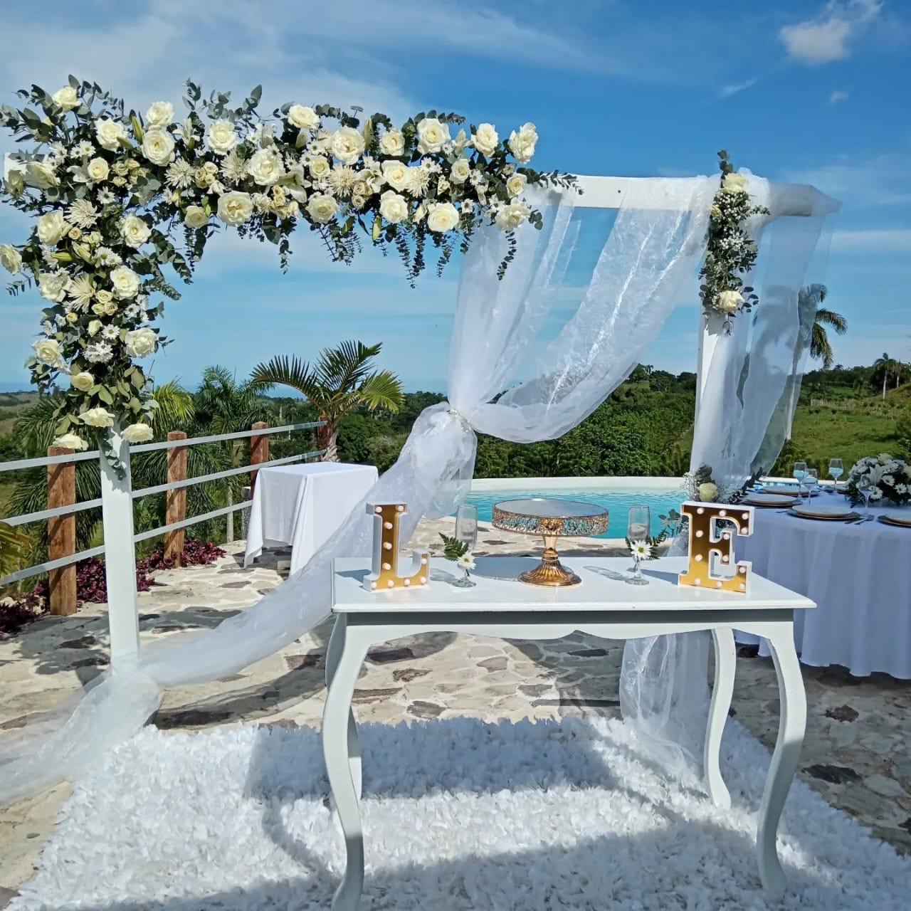 Mesa principal con arco de rosas blancas y letras iluminadas
